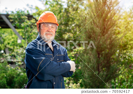 man with a beard in protective helmet and goggles. 70592417