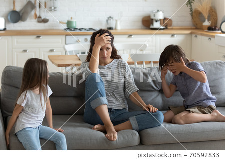 Tired exhausted mother having problem with naughty noisy kids Tired exhausted mother having problem with naughty noisy kids 70592833