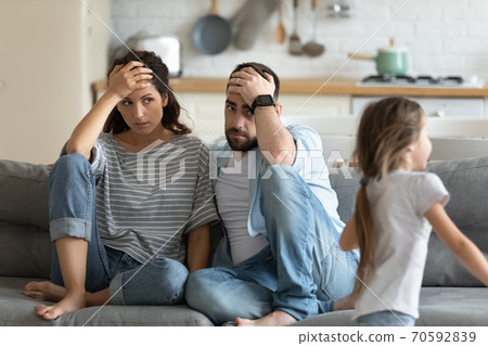 Tired mother and father having problem with noisy naughty daughter Tired mother and father having problem with noisy naughty daughter 70592839