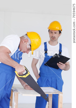 Builders in hardhats with tools 70594675