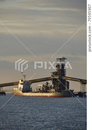 Photographed the autumn scenery of a cargo ship and a conveyor belt unloading to a cement factory in Hokuto City, Hokkaido in the early morning 70595907