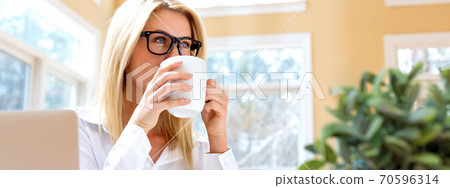 Happy young woman drinking coffee 70596314