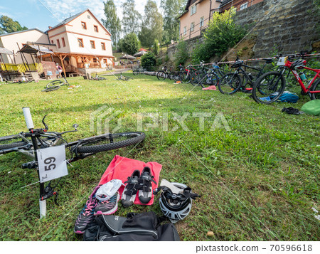 Lots of mountainbikes laying in the grass 70596618