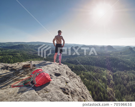Half naked man holds his hands on his hips and watc Half naked man holds his hands on his hips and watc 70596638