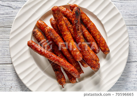 Short french sausages chipolata on a white plate Short french sausages chipolata on a white plate 70596665