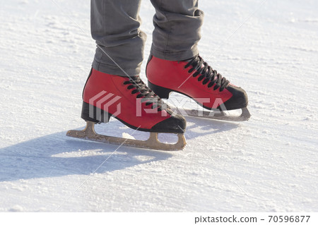 feet in red skates on an ice rink. hobbies and leisure. winter sports 70596877