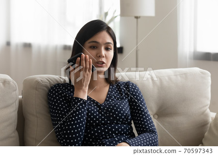 Asian woman talk on cellphone using loudspeaker Asian woman talk on cellphone using loudspeaker 70597343
