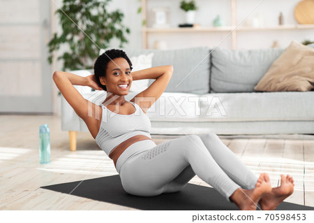 Full length portrait of beautiful African American woman keeping fit at home 70598453
