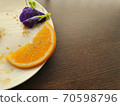 Piece of Orange with Pea Flower on dish 70598796