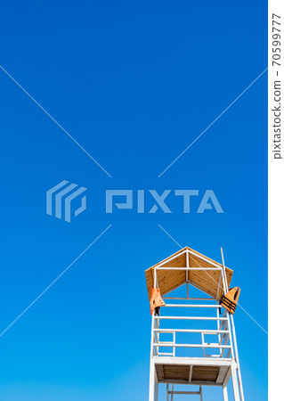 white wooden lifeboat tower on beach against sky. white wooden lifeboat tower on beach against sky. 70599777