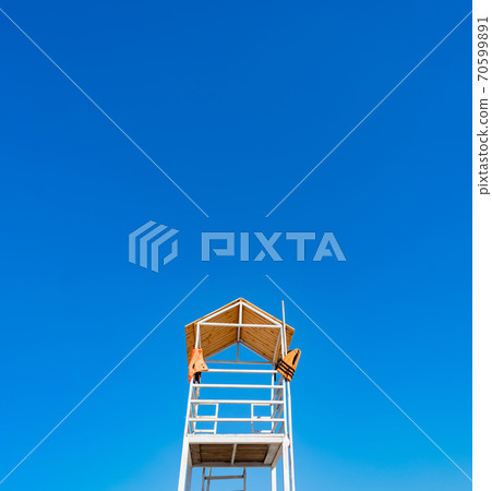 white wooden lifeboat tower on beach against sky. white wooden lifeboat tower on beach against sky. 70599891