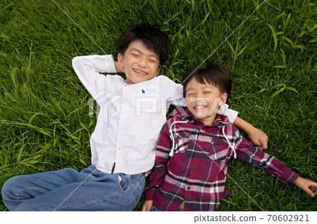 Boy lying on the grass Boy lying on the grass 70602921