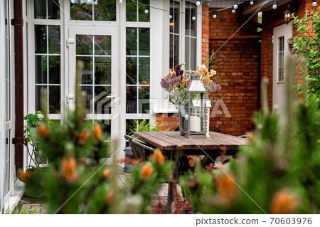 table in garden of house. candlesticks and bouquet 70603976