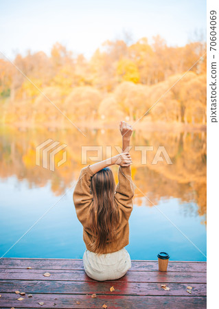 Fall concept - beautiful girl in autumn park on the lake Fall concept - beautiful girl in autumn park on the lake 70604069
