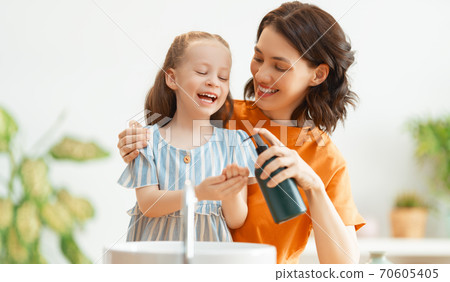 girl and her mother are washing hands 70605405