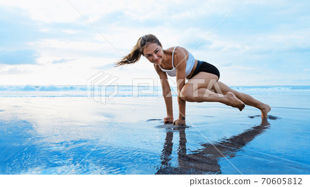 Sporty woman doing mountain climber exercise - run in plank position Sporty woman doing mountain climber exercise - run in plank position 70605812