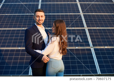 Beautiful couple by a solar panel Beautiful couple by a solar panel 70607175