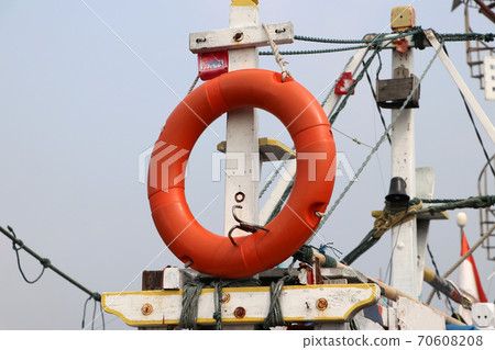 Safety life ring hanging on fishing boat masts. 70608208