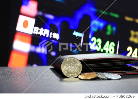Japanese five hundred Yen coins on obverse (JPY) and pile of other Japanese coins 70608269