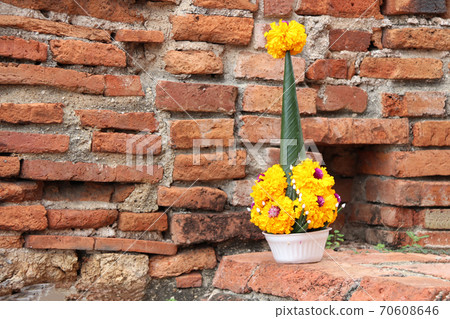 Rice offering from banana leaf and yellow marigold flower on the brick Rice offering from banana leaf and yellow marigold flower on the brick 70608646