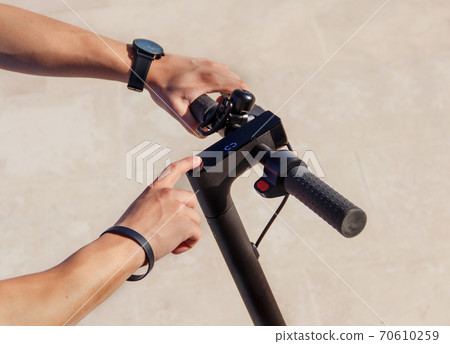 Young man powering on an electric scooter Young man powering on an electric scooter 70610259