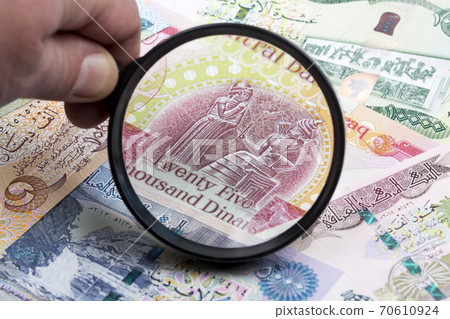 Iraqi dinar in a magnifying glass 70610924