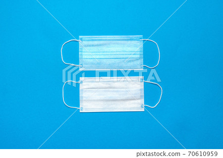 Disposable blue medical face masks on blue background Disposable blue medical face masks on blue background 70610959