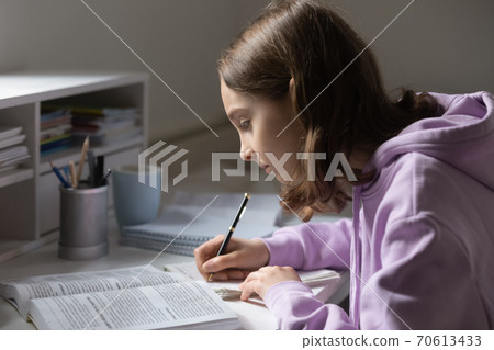 Focused teen girl study making assignment at home Focused teen girl study making assignment at home 70613433