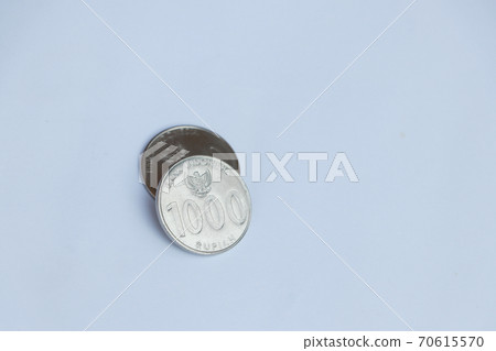 Two coins of one thousand Rupiah Indonesia money on the white background. Concept of finance. Two coins of one thousand Rupiah Indonesia money on the white background. Concept of finance. 70615570