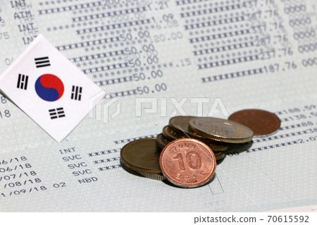 Heap of South Korea won coin money and mini South Korea flag on the book bank.  70615592