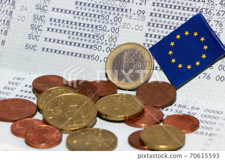 Heap of Euro coin money and mini European Union flag on the book bank. Concept of Saving money. Heap of Euro coin money and mini European Union flag on the book bank. Concept of Saving money. 70615593
