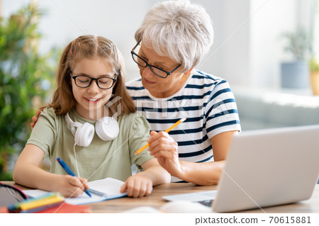 Girl doing homework or online education. Girl doing homework or online education. 70615881