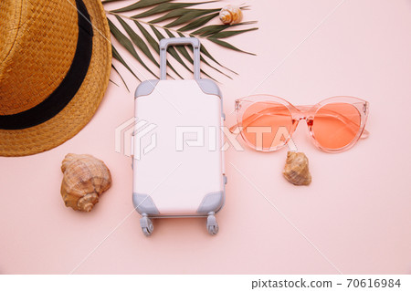 Pink suitcase and summer accessories on pink background. Travel, summer vacation or tourism concept Pink suitcase and summer accessories on pink background. Travel, summer vacation or tourism concept 70616984