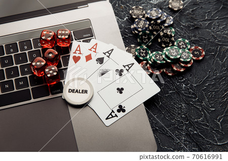 Online casino. Gambling chips, cards with aces and red dices on laptop keyboard. Online casino. Gambling chips, cards with aces and red dices on laptop keyboard. 70616991