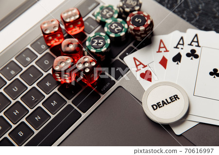 Online casino concept. Gambling chips, cards with aces and red dices on laptop keyboard Online casino concept. Gambling chips, cards with aces and red dices on laptop keyboard 70616997