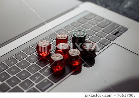 Online casino theme. Gambling chips and red dices on keyboard 70617003