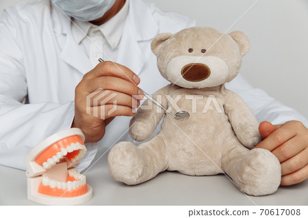 Dentist chekup teeth of teddy bear. Children dentist concept Dentist chekup teeth of teddy bear. Children dentist concept 70617008