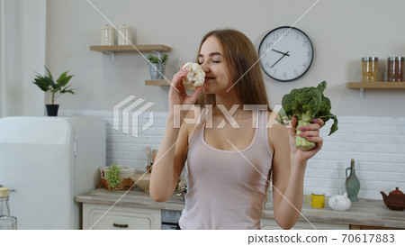Girl recommending eating raw vegetable food. Showing broccoli and cauliflower. Weight loss, diet Girl recommending eating raw vegetable food. Showing broccoli and cauliflower. Weight loss, diet 70617883