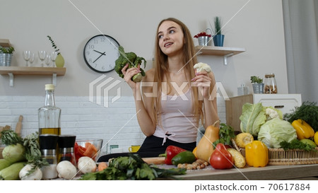 Girl recommending eating raw vegetable food. Showing broccoli and cauliflower. Weight loss, diet Girl recommending eating raw vegetable food. Showing broccoli and cauliflower. Weight loss, diet 70617884
