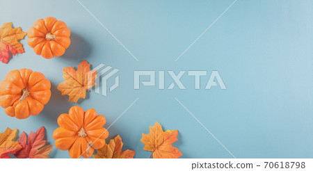 Thanksgiving background decoration from dry leaves and pumpkin on  pastel blue background. Flat lay, top view with copy space. 70618798