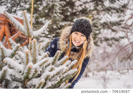 Young woman enjoys a winter snowy day in a snowy forest 70619087