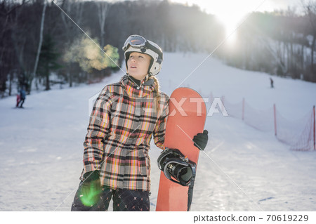 Woman snowboarder on a sunny winter day at a ski resort Woman snowboarder on a sunny winter day at a ski resort 70619229
