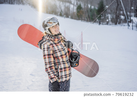 Woman snowboarder on a sunny winter day at a ski resort 70619232
