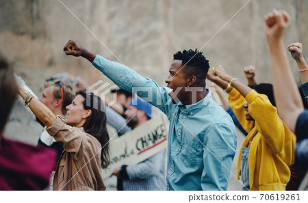 Group of people activists with raised fists protesting on streets, BLM demonstration concept. Group of people activists with raised fists protesting on streets, BLM demonstration concept. 70619261