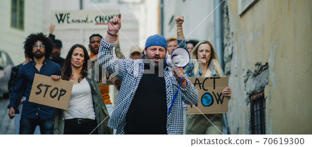 Group of people activists protesting on streets, strike and demonstration concept. Group of people activists protesting on streets, strike and demonstration concept. 70619300