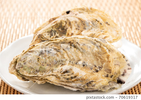 So-called "microwave oysters" that are heated in a microwave oven with their shells attached. Easy cooking image of oysters with shells. 70619317