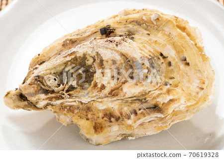 所謂的“微波牡蠣”是在微波爐中將其外殼附著在烤箱上加熱的。牡蠣的容易的烹調圖像與殼的。 70619328
