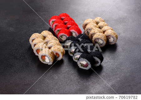 Fresh delicious beautiful sushi rolls on a dark background Fresh delicious beautiful sushi rolls on a dark background 70619782