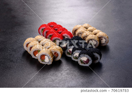 Fresh delicious beautiful sushi rolls on a dark background 70619783