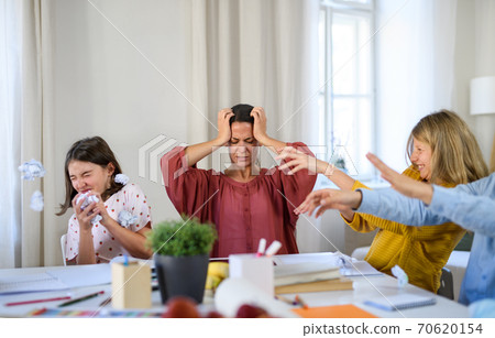 Group of misbehaving homeschooling children with teacher studying indoors, coronavirus concept. Group of misbehaving homeschooling children with teacher studying indoors, coronavirus concept. 70620154